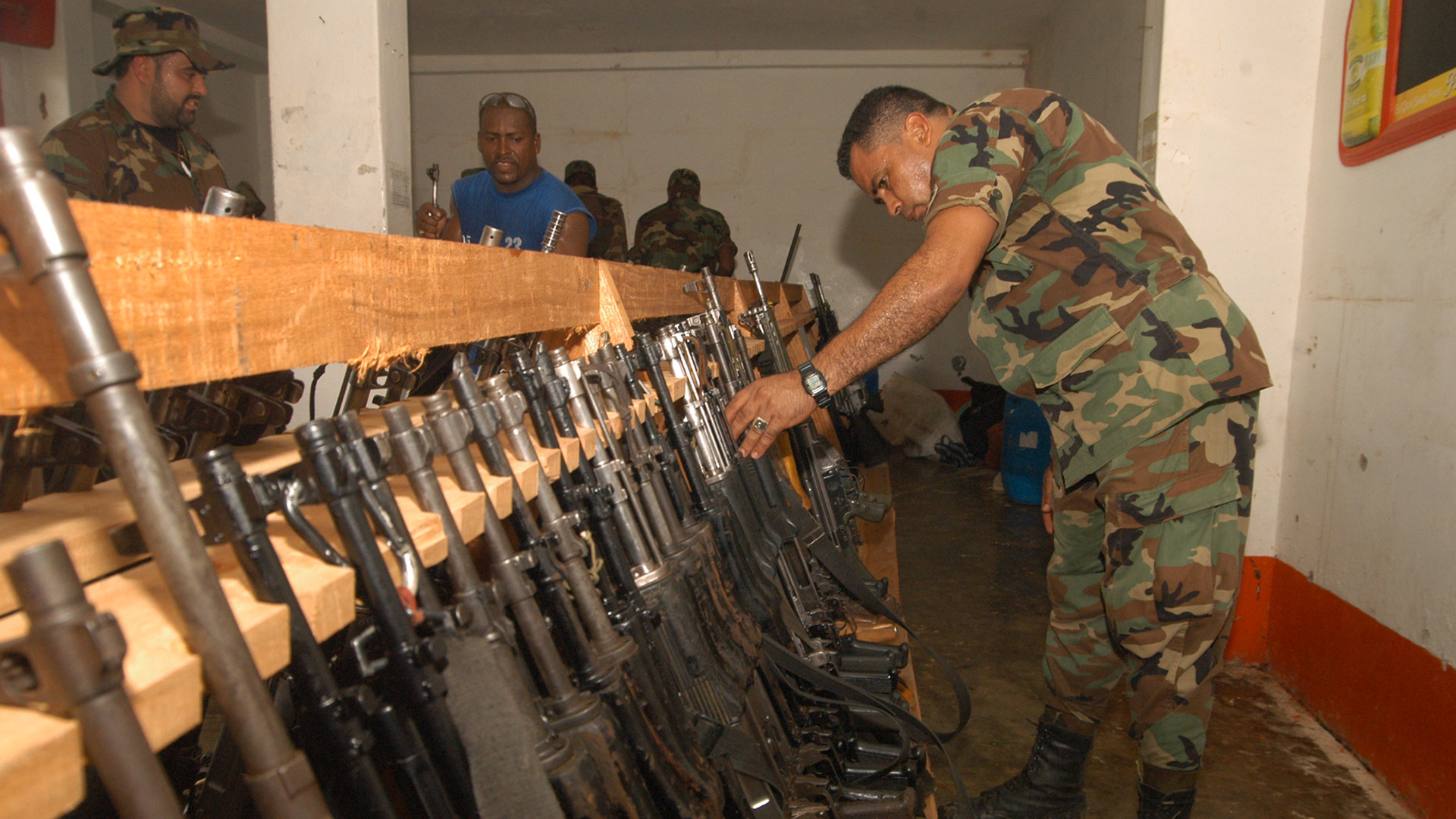 A solider inspects a row of rifles