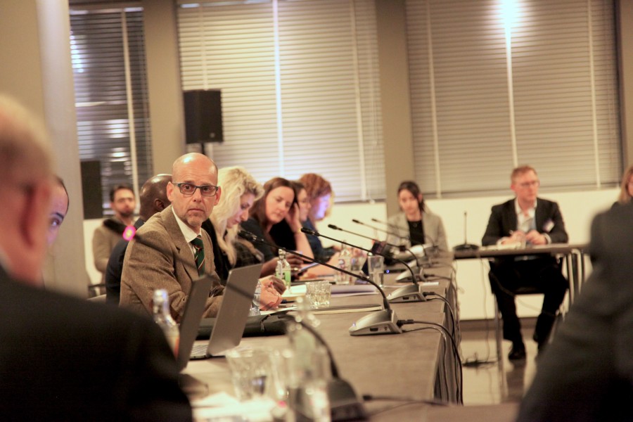 people in business attire seated around a table
