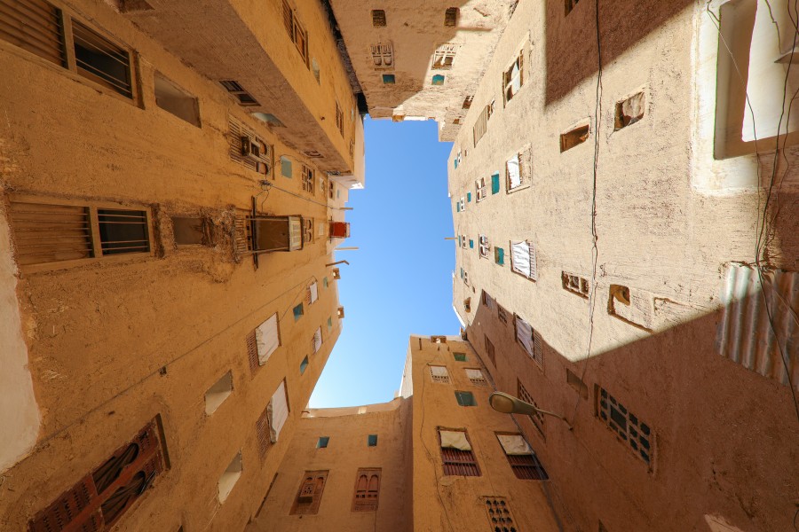 The sun shines into an urban courtyard of what it appears to be residential buildings.