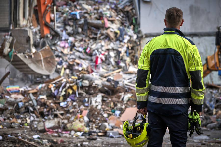A first responder faces a destroyed building in Ukraine