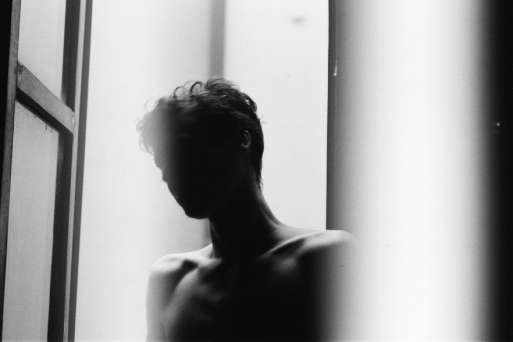Black and white photo of a shadowed figure in a window.
