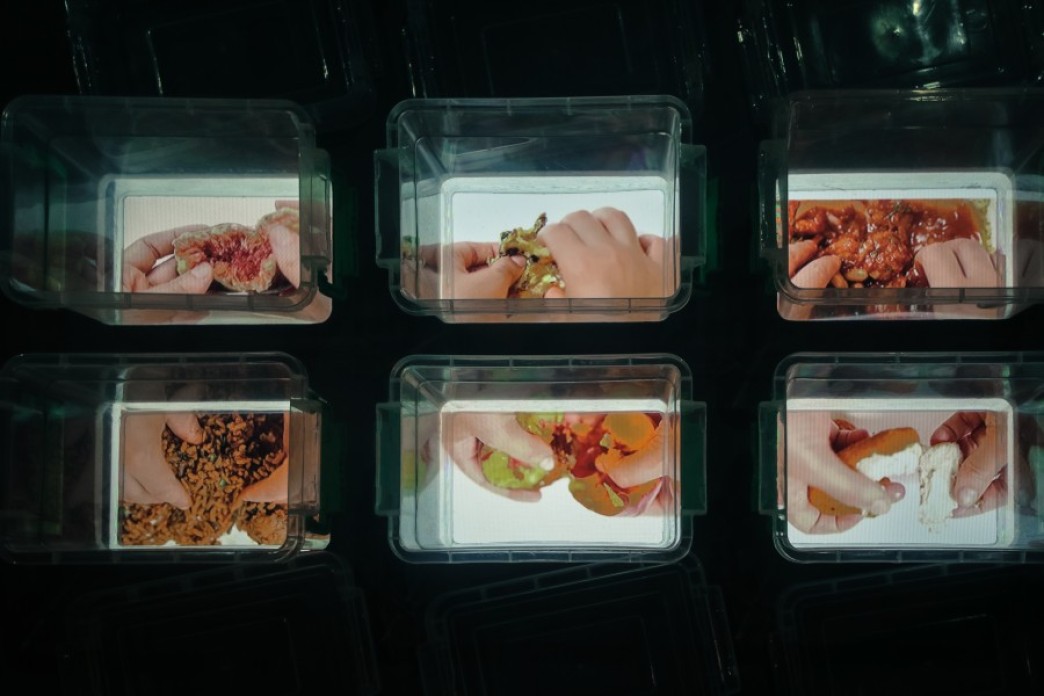 Six containers are arranged in a grid, each one with an image in the bottom of two hands interacting with fruit and other food items.