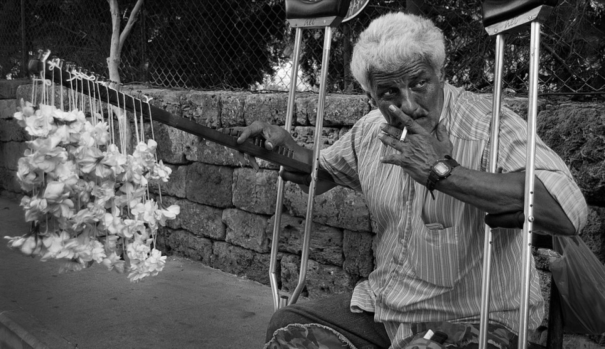 Image of a Lebanese victim of the 1975 civil war who lost his home, his leg, and his family; sitting on a swing and smoking his cigarette
