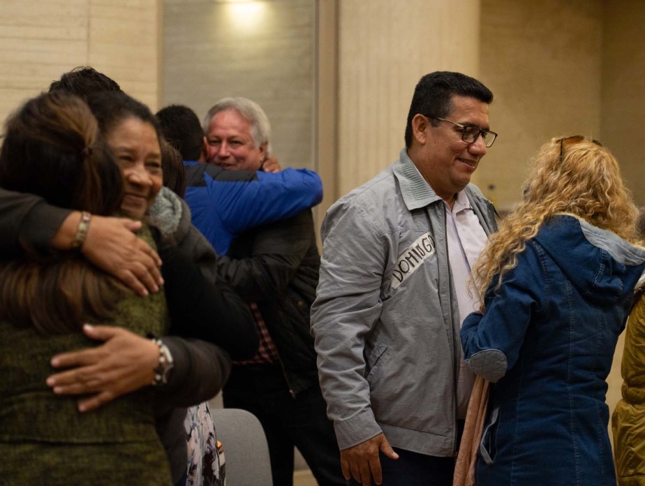 Several people hug and talk to each other.