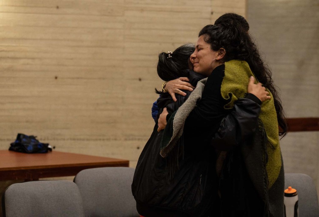 Two women embrace each other.