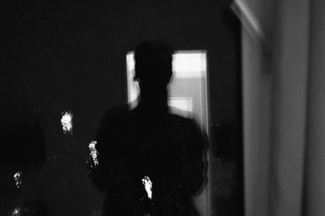 An artistic photograph of a silhouette with bright white marks or lights, in black and white