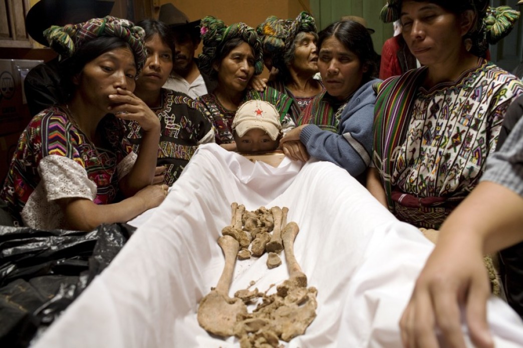 A skeleton with a crowd of people surrounding it.