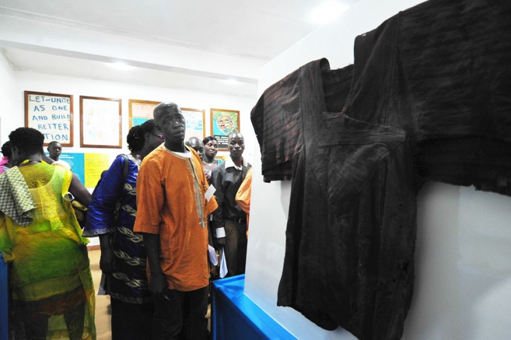 People looking at a garment at a museum.