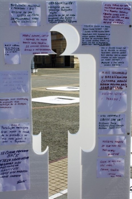A wall with the shape of a human cut out and writing surrounding the hole.