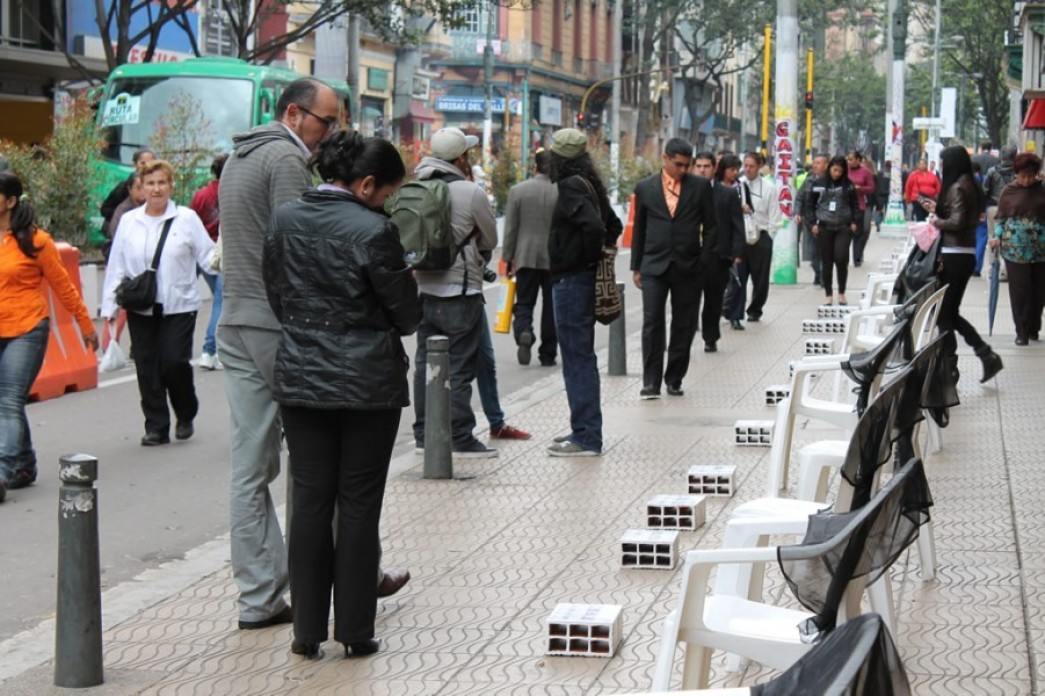 An urban street with pieces of concrete lined up along it.