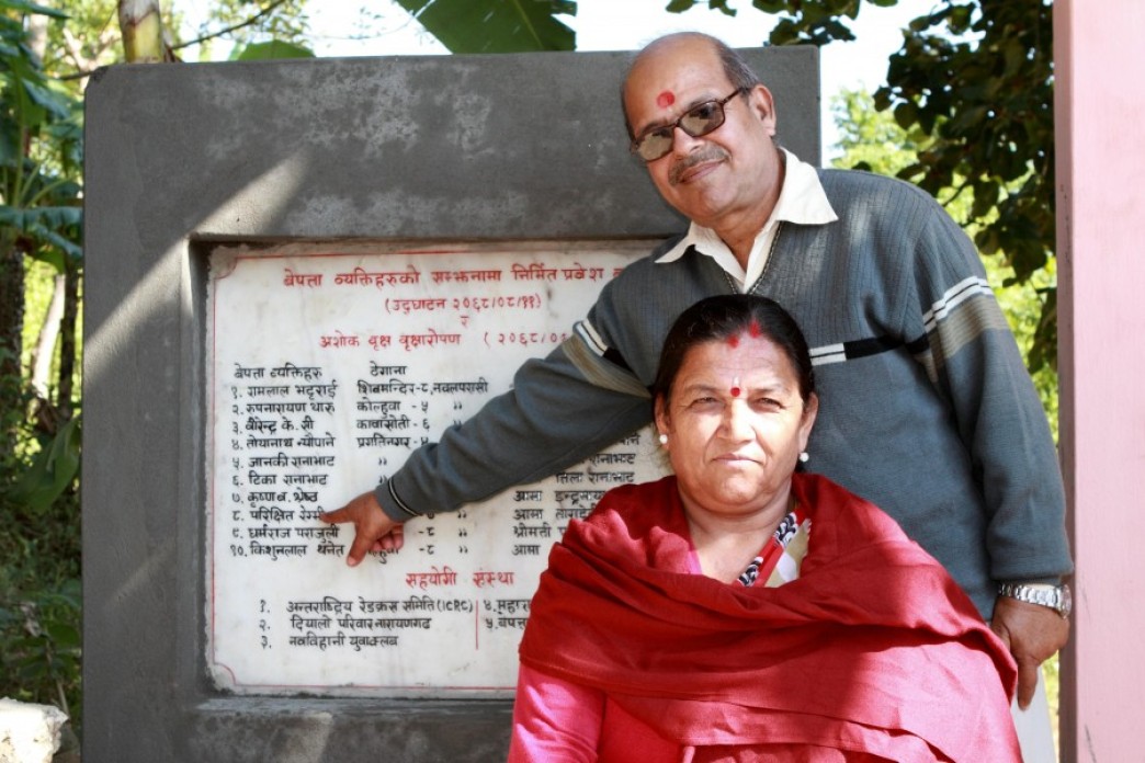 Two people pointing to a monument.