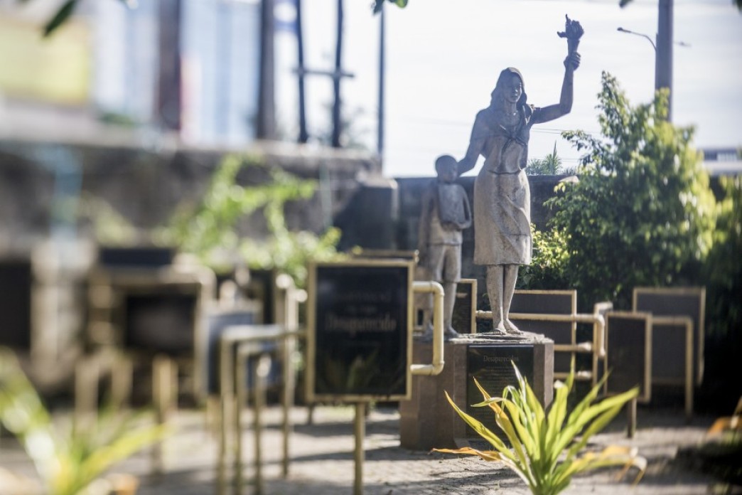 A monument with a statue of a woman and a child.
