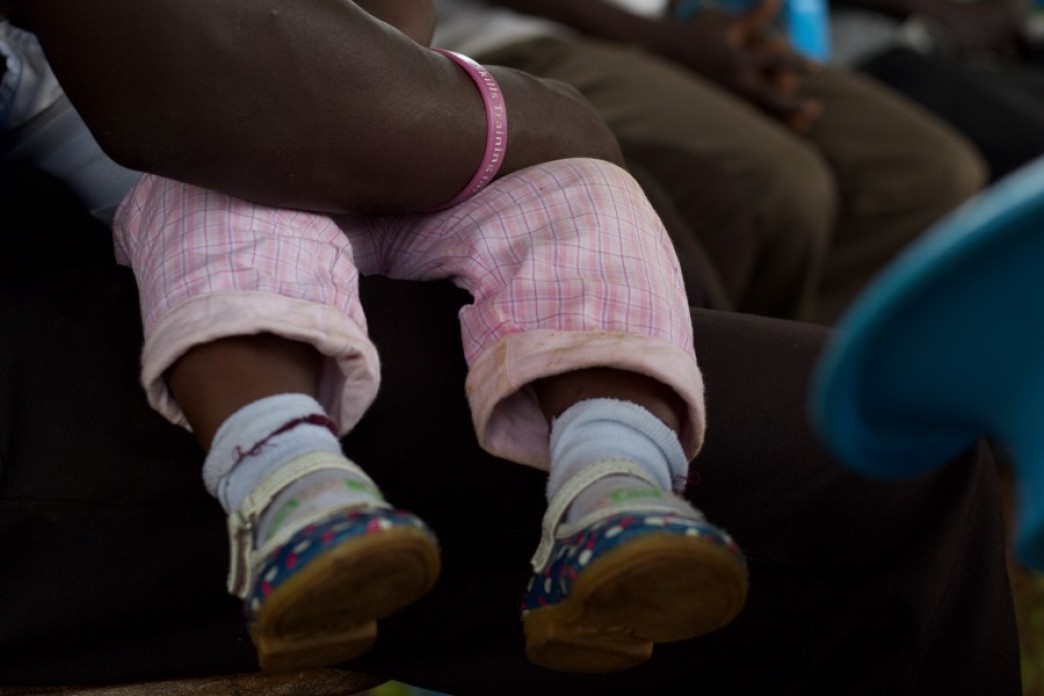 An infant's feet dangling from a chair.