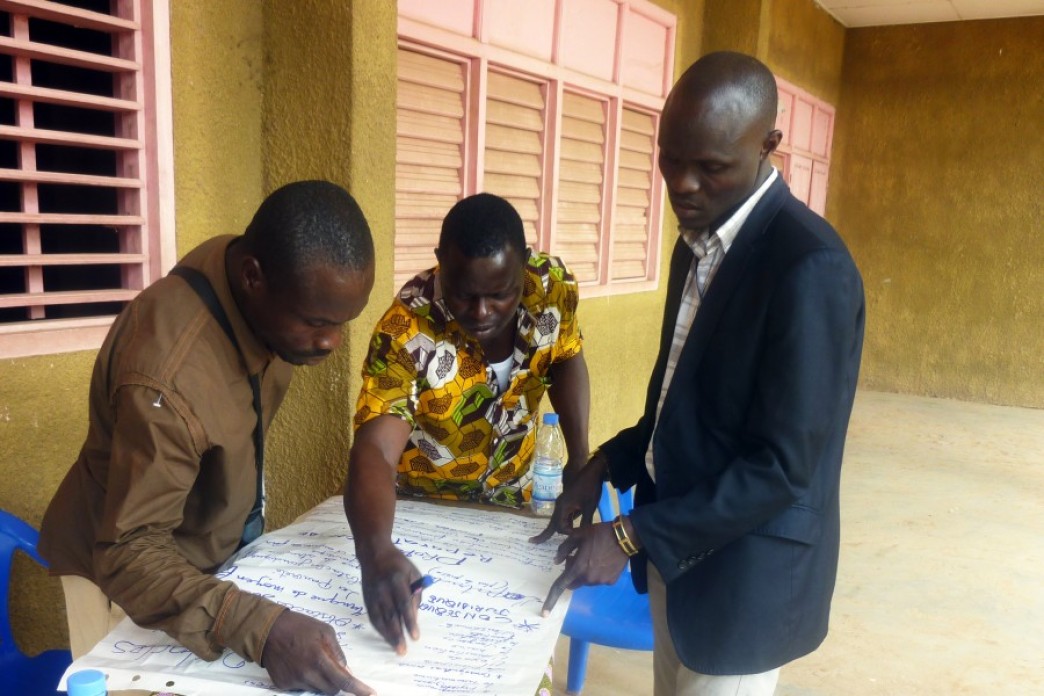 Men around a table writing.