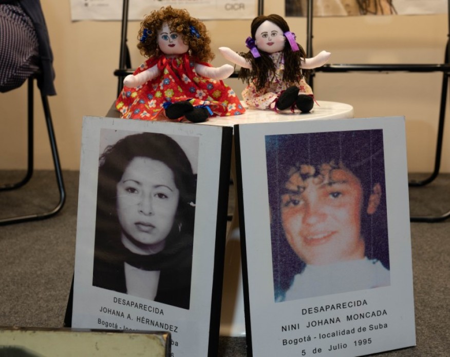Dolls with photographs of young women beneath.