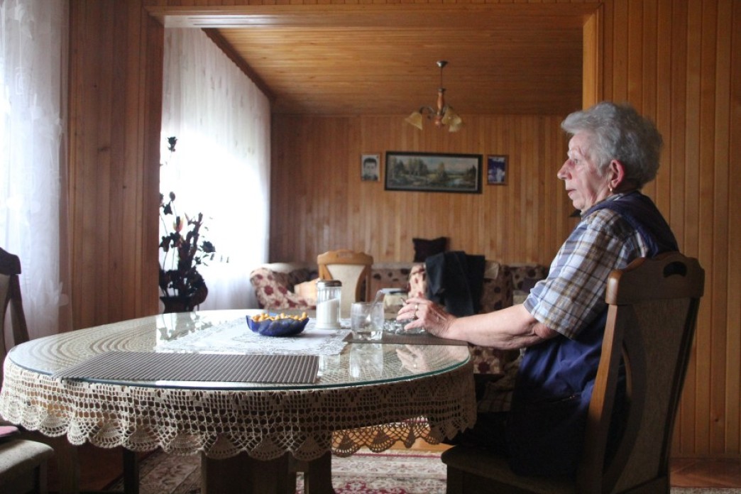 A woman sitting alone at a kitchen table.