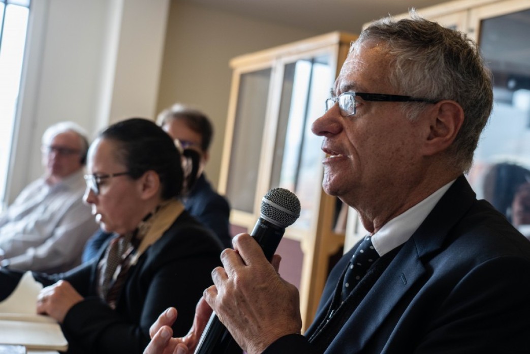 A man at a table presenting.