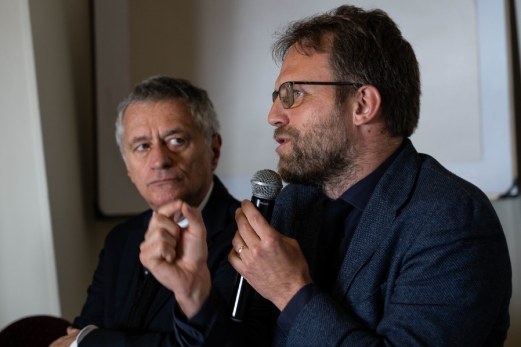 Two men presenting onstage.