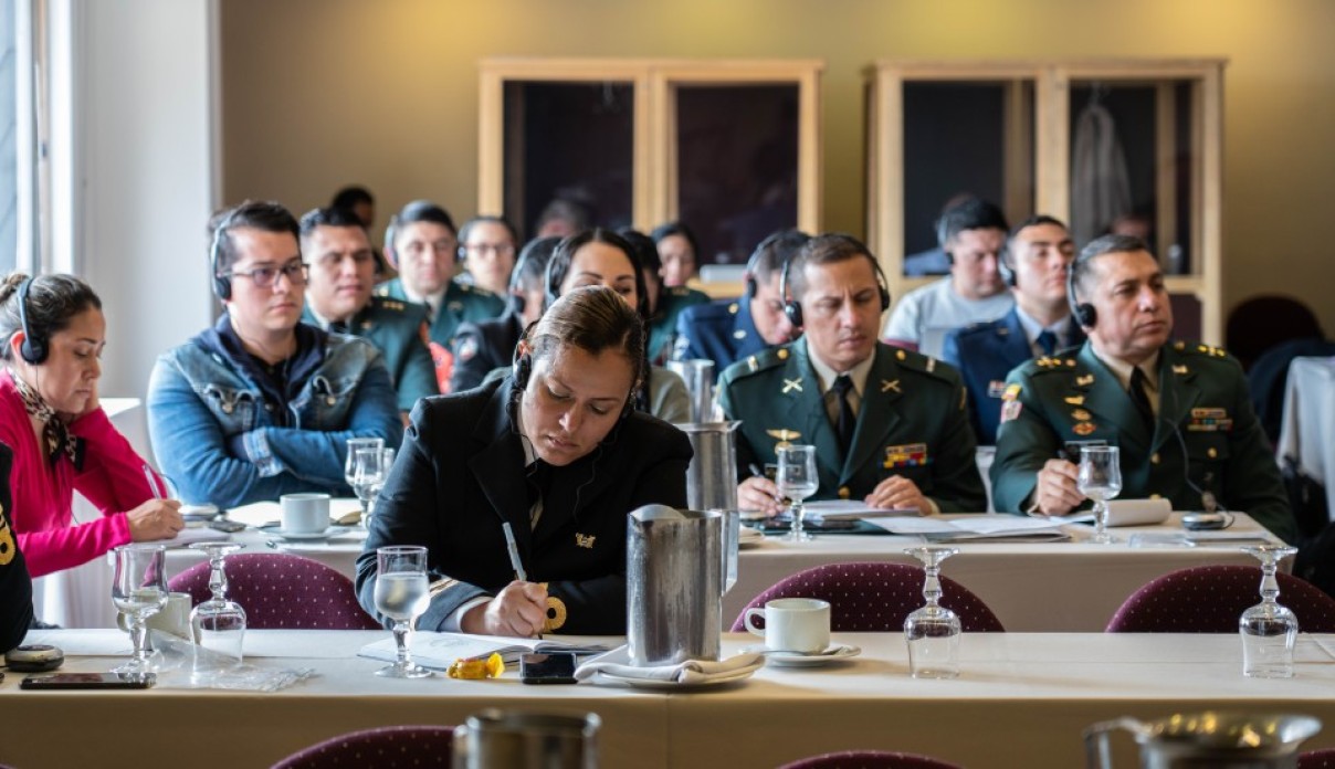 People in uniform watching a presentation.